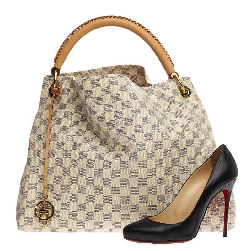 This authentic Louis Vuitton Artsy Damier MM is an elegant and iconic bag that adds a stylish flair to any outfit. Crafted from Louis Vuitton's damier azur canvas, this artsy hobo features single looped hand-crafted leather handle, key-hanger bag