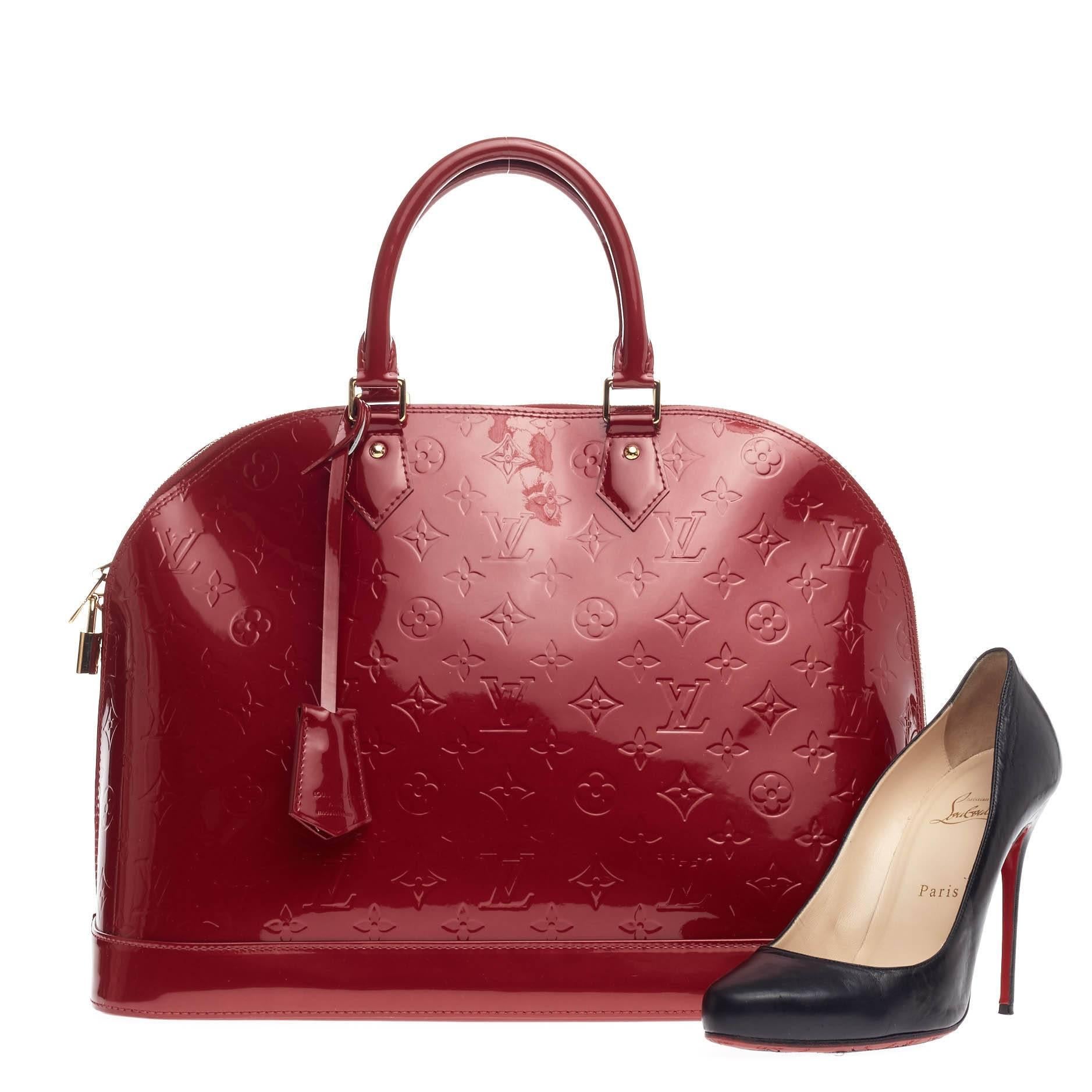 This authentic Louis Vuitton Alma Monogram Vernis GM is a fresh and elegant spin on a classic style that is perfect for all seasons. Crafted from Louis Vuitton's pomme d’amour red monogram vernis, this dome-shaped satchel features double rolled