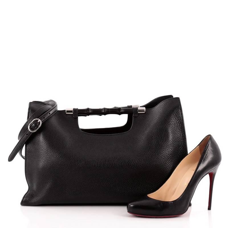 This authentic Gucci Bamboo Convertible Daily Tote Leather Wide is a chic, must-have made for everyday use. Crafted from supple black leather, this simple yet stylish tote features Gucci's signature sturdy lacquered bamboo hand grips, detachable