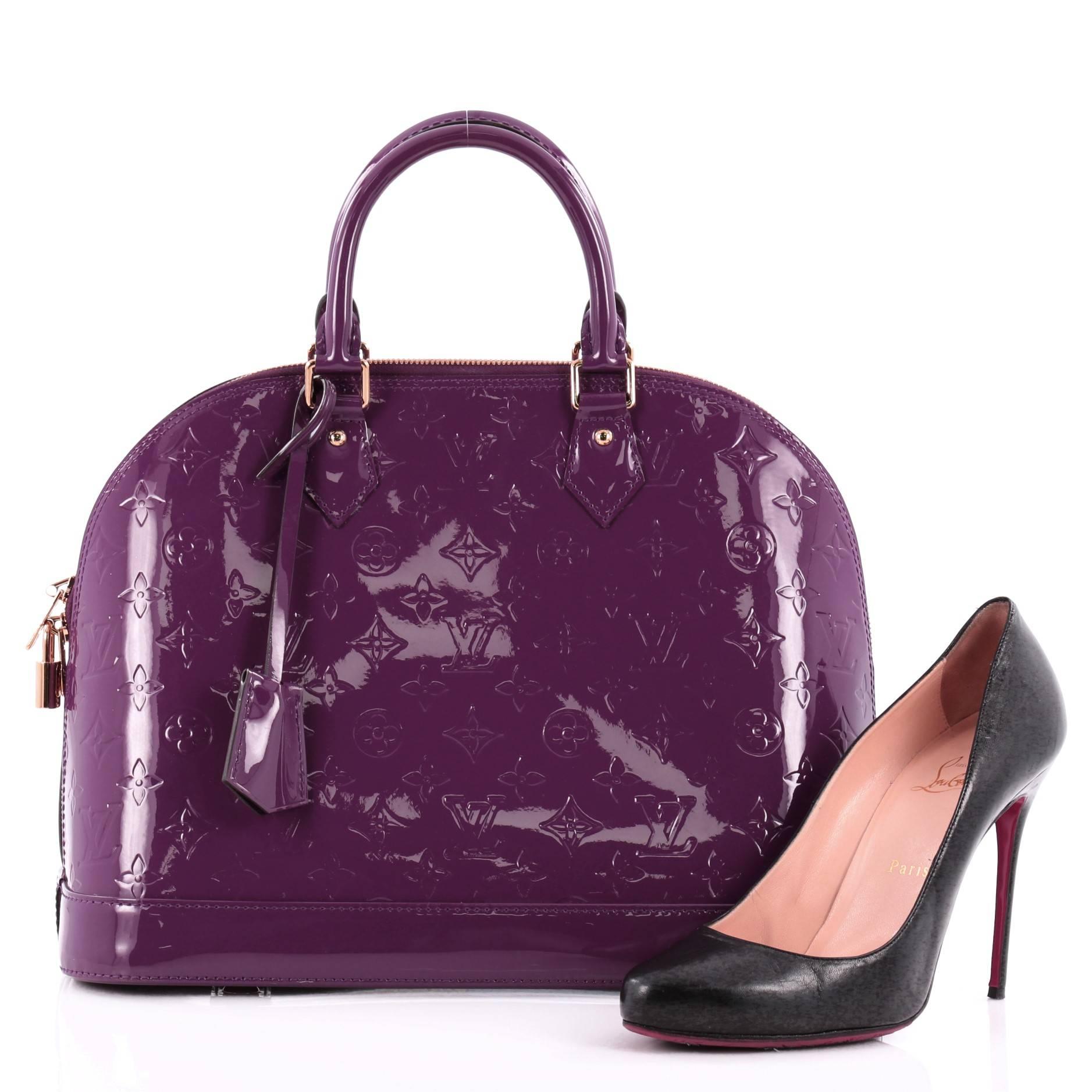 This authentic Louis Vuitton Alma Monogram Vernis MM is a fresh and elegant spin on a classic style that is perfect for summer. Crafted from Louis Vuitton's glossy amethyste purple monogram vernis patent leather, this bag features dual-rolled