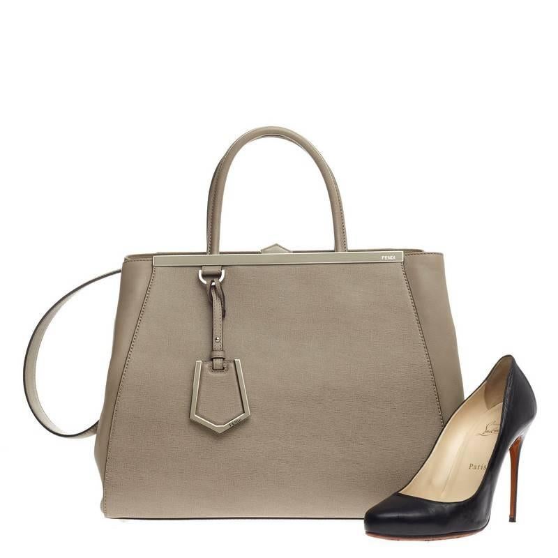 This authentic Fendi 2Jours Leather Medium is impeccably stylish simple silhouette and structured design. Finely crafted in sturdy taupe leather with soft calfskin sides, this popular tote features a shining top bar that dons the Fendi brand name,