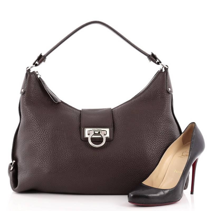 This authentic Salvatore Ferragamo New Fanisa Hobo Leather Medium exudes sophistication and elegance perfect for everyday work. Crafted in brown pebbled leather, this hobo features a single looped leather shoulder strap, accented with silver Gancini