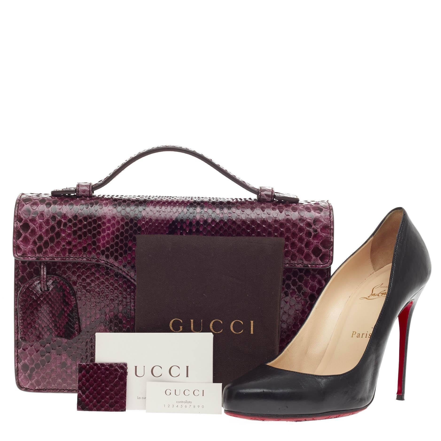 This authentic Gucci Lady Lock Briefcase Clutch Python is the perfect small accessory for work or  night out. Crafted in purple genuine python skin, this briefcase features top handle, lady lock closure, frontal flap, leather clochette and