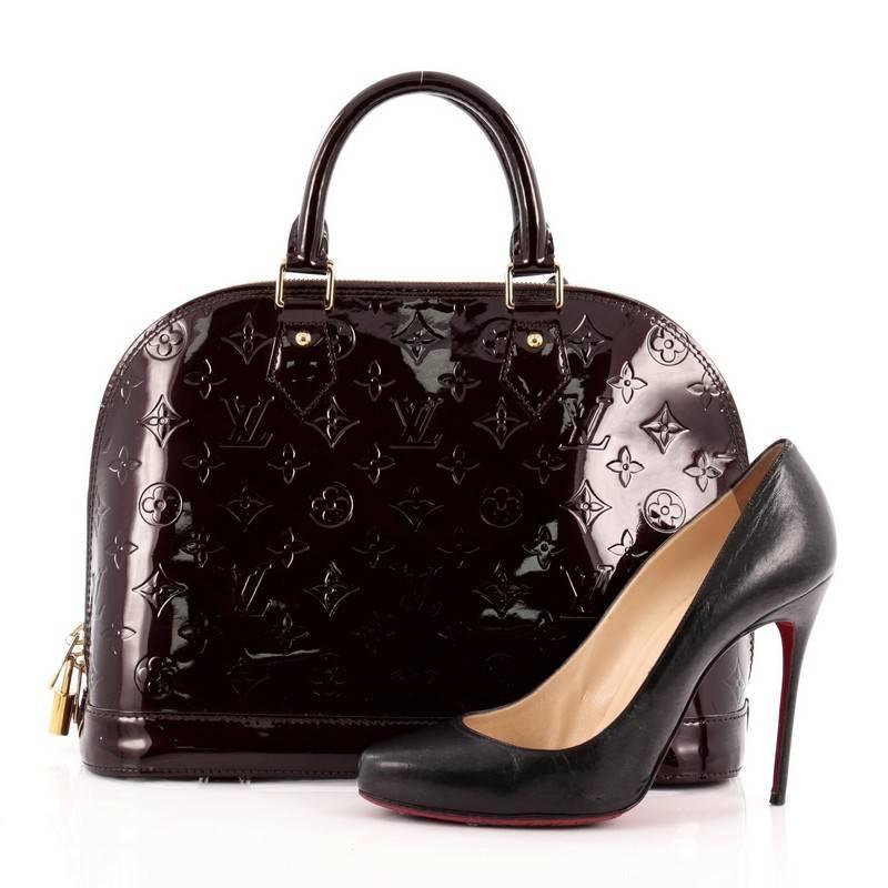 This authentic Louis Vuitton Alma Monogram Vernis PM is a fresh and elegant spin on a classic style that is perfect for all seasons. Crafted from Louis Vuitton's amarante monogram vernis patent leather, this dome-shaped satchel features dual-rolled