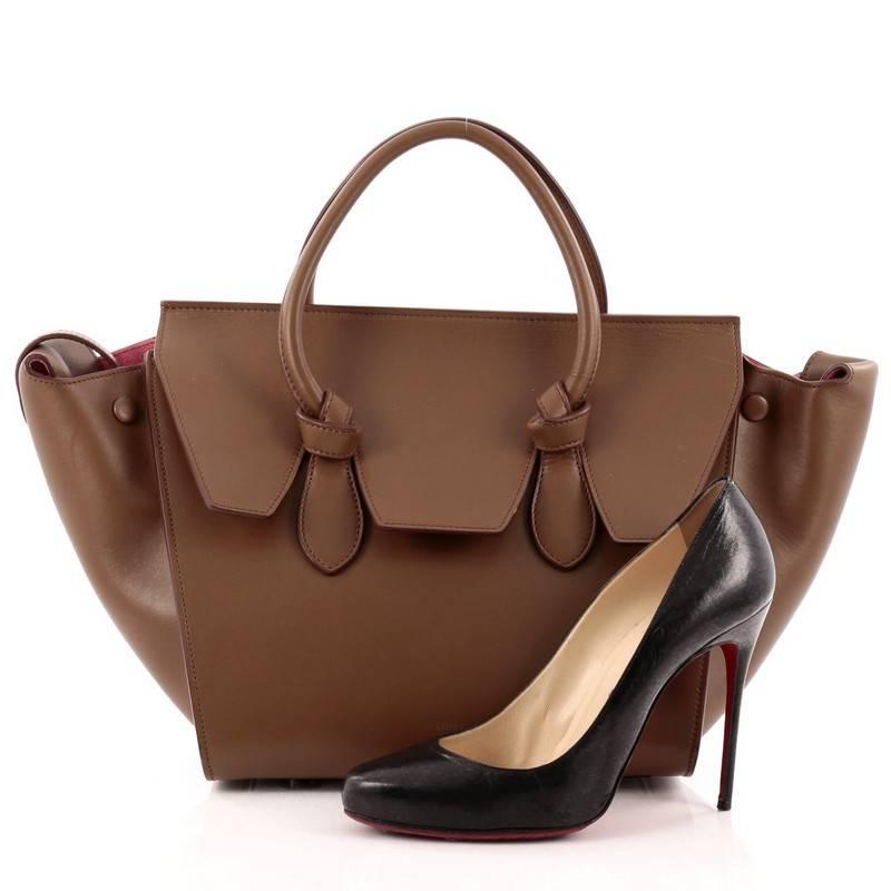This authentic Celine Tie Knot Tote Smooth Leather Mini is an absolute must-have for serious fashionistas. Crafted from brown leather, this boxy, chic tote features dual-rolled leather handles with signature knot accents, protective base studs,