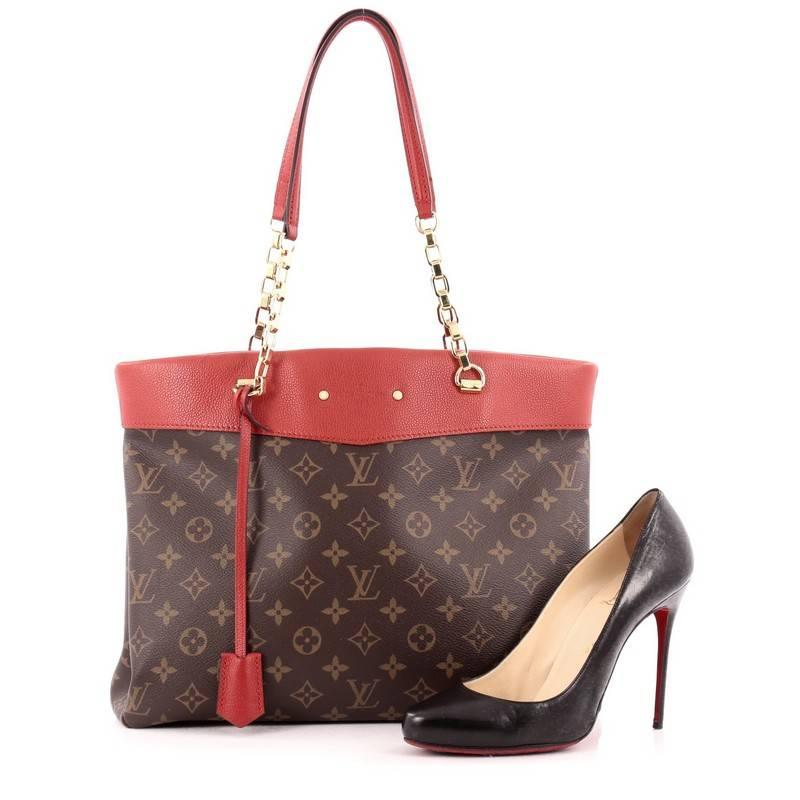 This authentic Louis Vuitton Pallas Shopper Monogram Canvas and Calf Leather from the brand's Pre-Fall 2015 Collection is a luxurious, city tote made for the modern woman. Crafted from brown monogram coated canvas with red calf leather trims, this