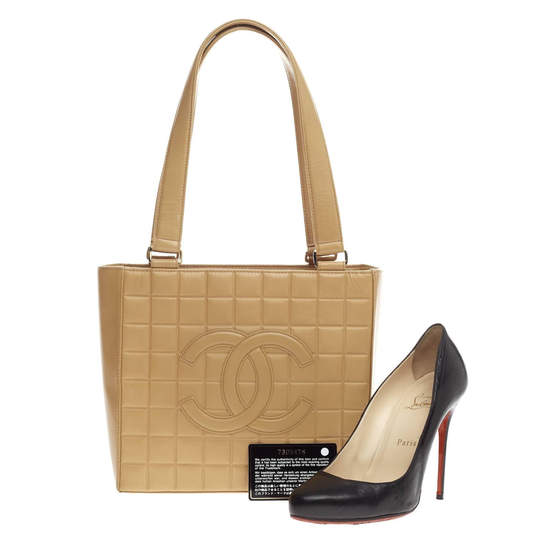 This authentic Chanel Chocolate Bar CC Tote Quilted Leather Small has an elegant and classic style to complement your sophisticated looks. Crafted from tan quilted leather, this tote features chocolate bar quilting, dual tall leather strap,