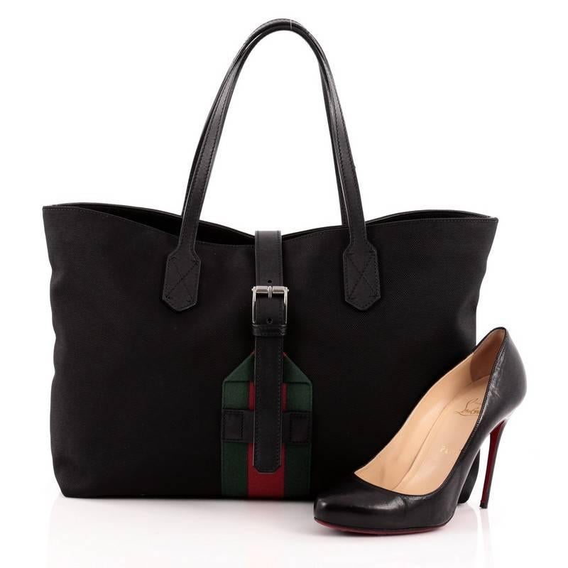 This authentic Gucci Web Buckle Tote Techno Canvas Large is modern and sophisticated in design. Crafted in black canvas with signature striped webbing, this elegant tote features tall dual-slim handles, and silver-tone hardware accents. Its buckle