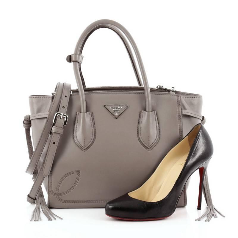 This authentic Prada Tassel Twin Pocket Tote City Calf Small is elegant in its simplicity and structure. Crafted from argilla taupe city calf leather, this tote features dual-rolled handles, removable adjustable shoulder strap, iconic inverted Prada
