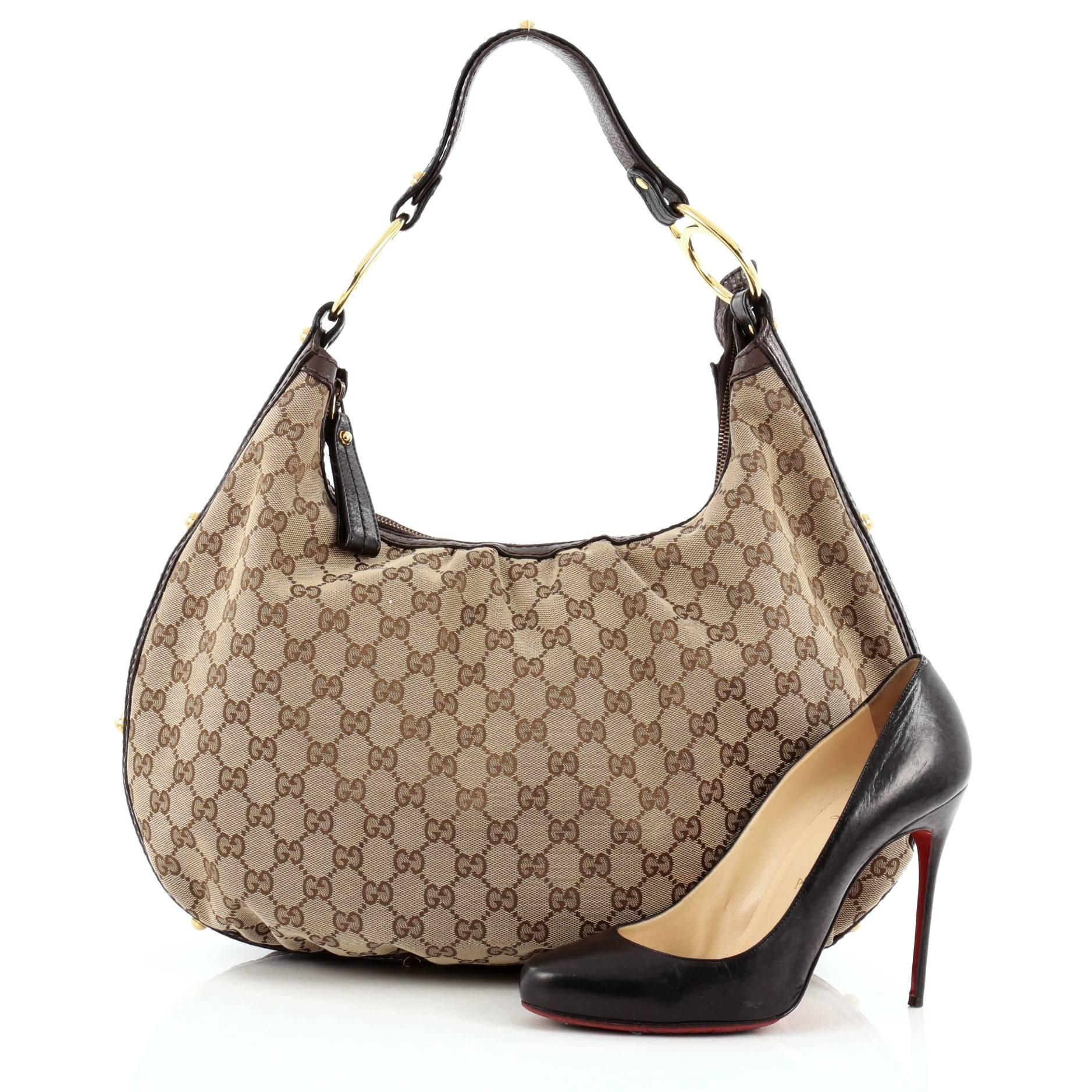 This authentic Gucci Interlocking Hobo GG Canvas Medium is an easy to carry, everyday accessory that is both stylish and functional. Crafted from Gucci's brown GG canvas, this no-fuss hobo features a pleated silhouette, leather strap with Gucci