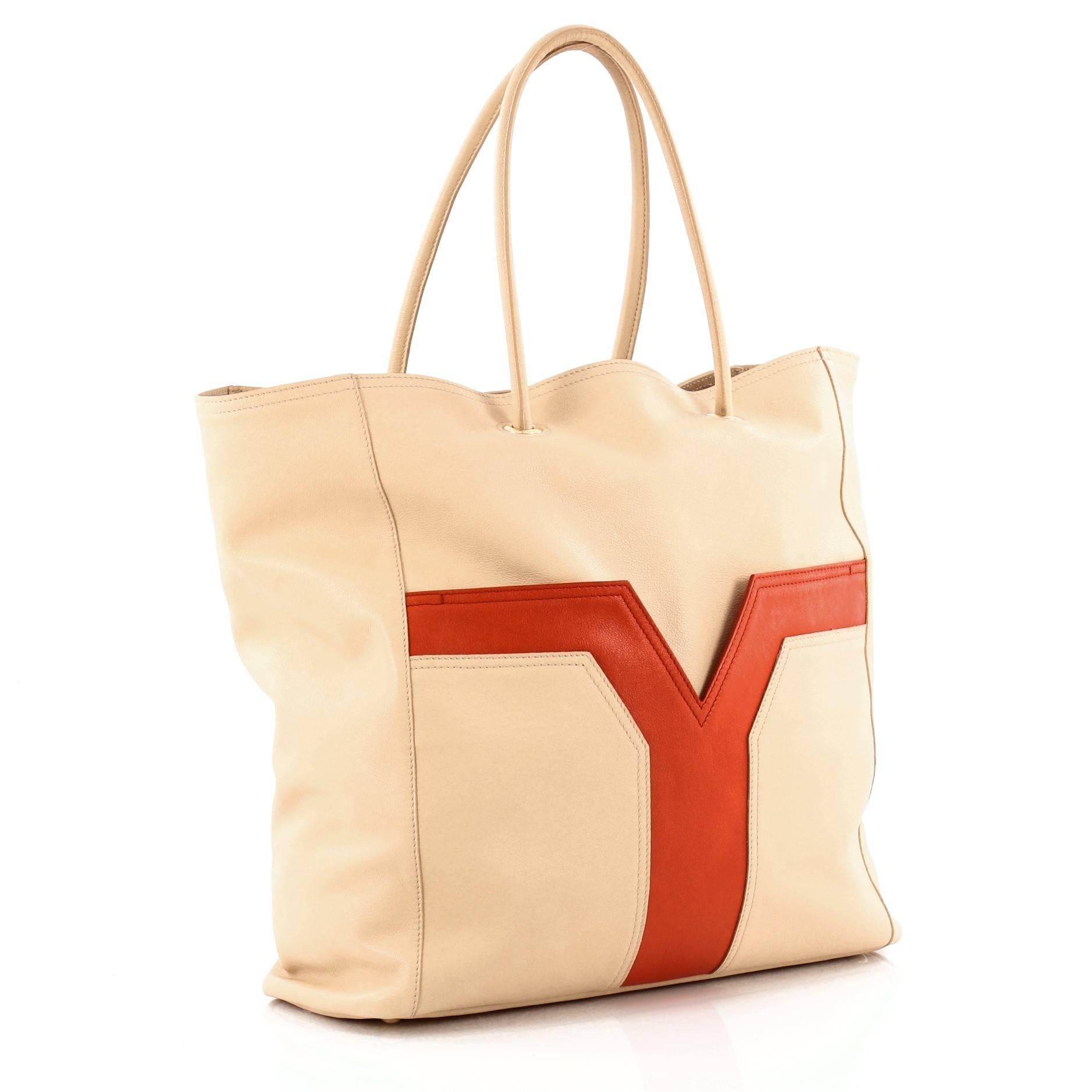 This authentic Saint Laurent Lucky Chyc Tote Leather Medium is a  perfect everyday tote made for serious fashionistas. Crafted from beige leather, this no-fuss shopping tote features dual-rolled leather handles, exterior front pocket with distinct