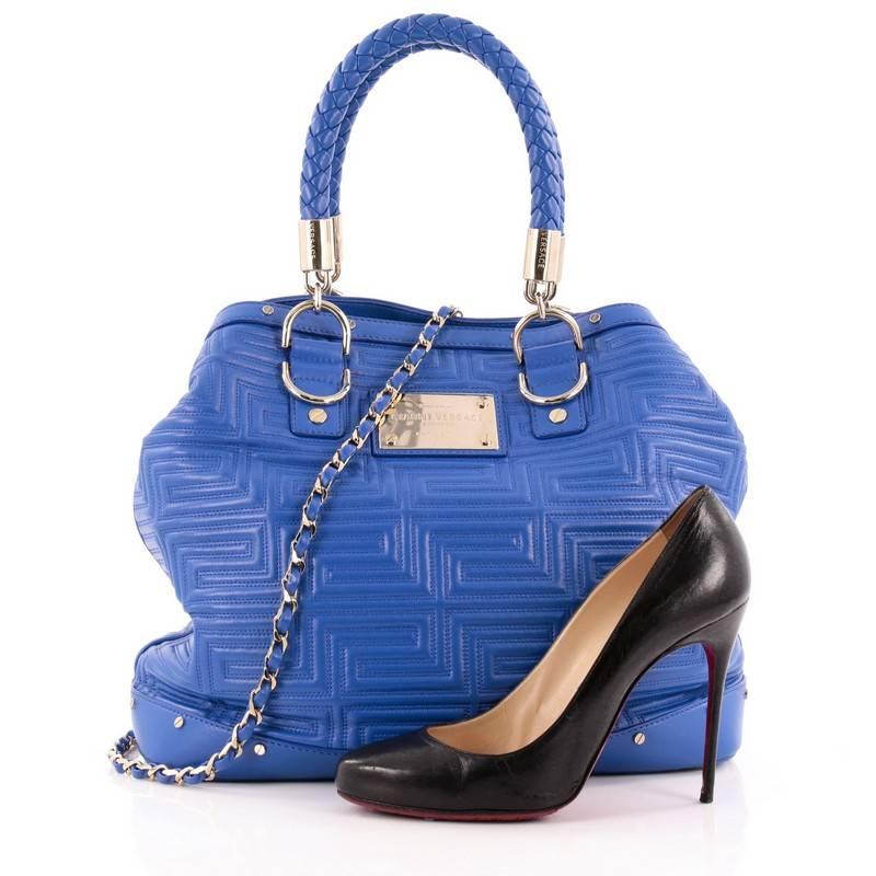 This authentic Versace Snap Out Of It Convertible Tote Matelasse Leather Large is a modern, sleek bag perfect for daily excursions. Crafted from striking blue embossed leather, this luxurious bag features greek key quilting details, dual woven