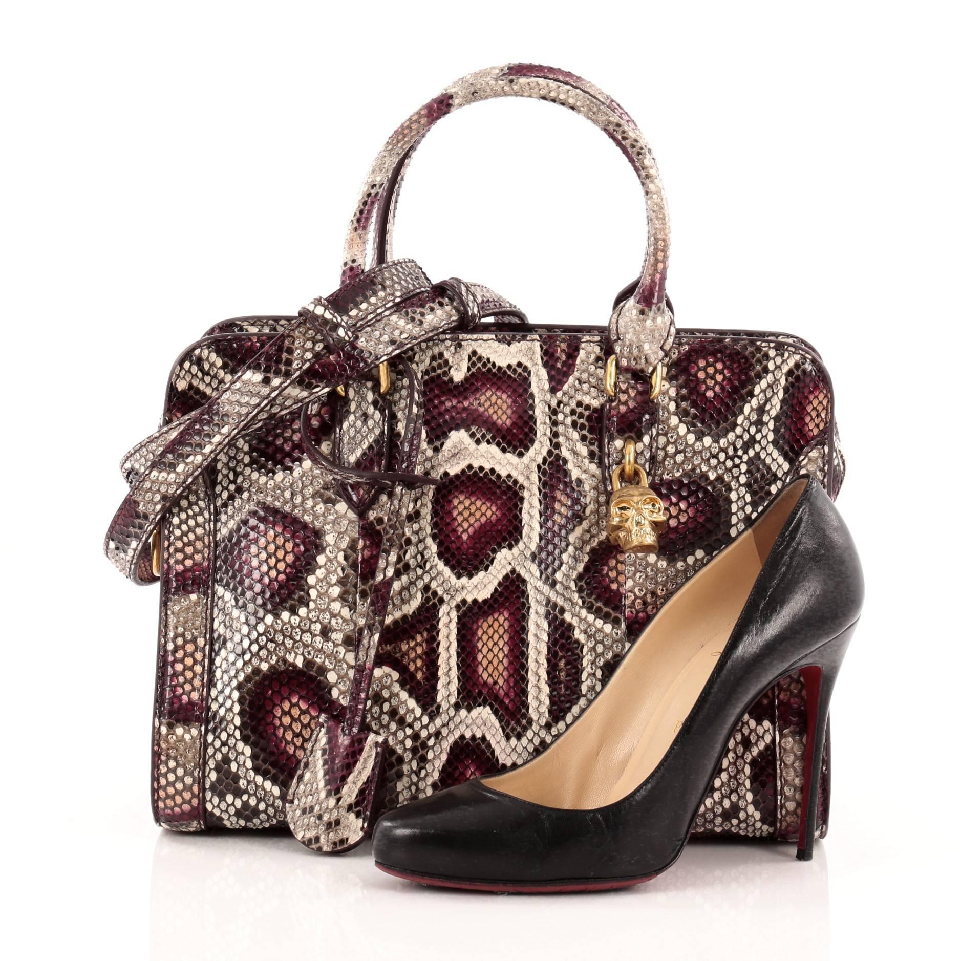 This authentic Alexander McQueen Padlock Zip Around Tote Python Medium displays an architectural elegance perfect for the sophisticated women. Crafted from multi-colored python skin, this structured bag features dual-rolled leather handles,
