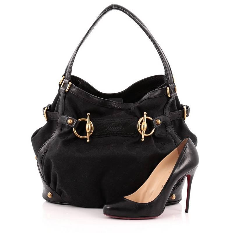 This authentic Gucci Jockey Tote GG Canvas Medium is perfect for all seasons. Crafted from black GG canvas, this bag features dual-flat leather top handles, black leather trims, horesbit and stud detailing and gold-tone hardware accents. Its