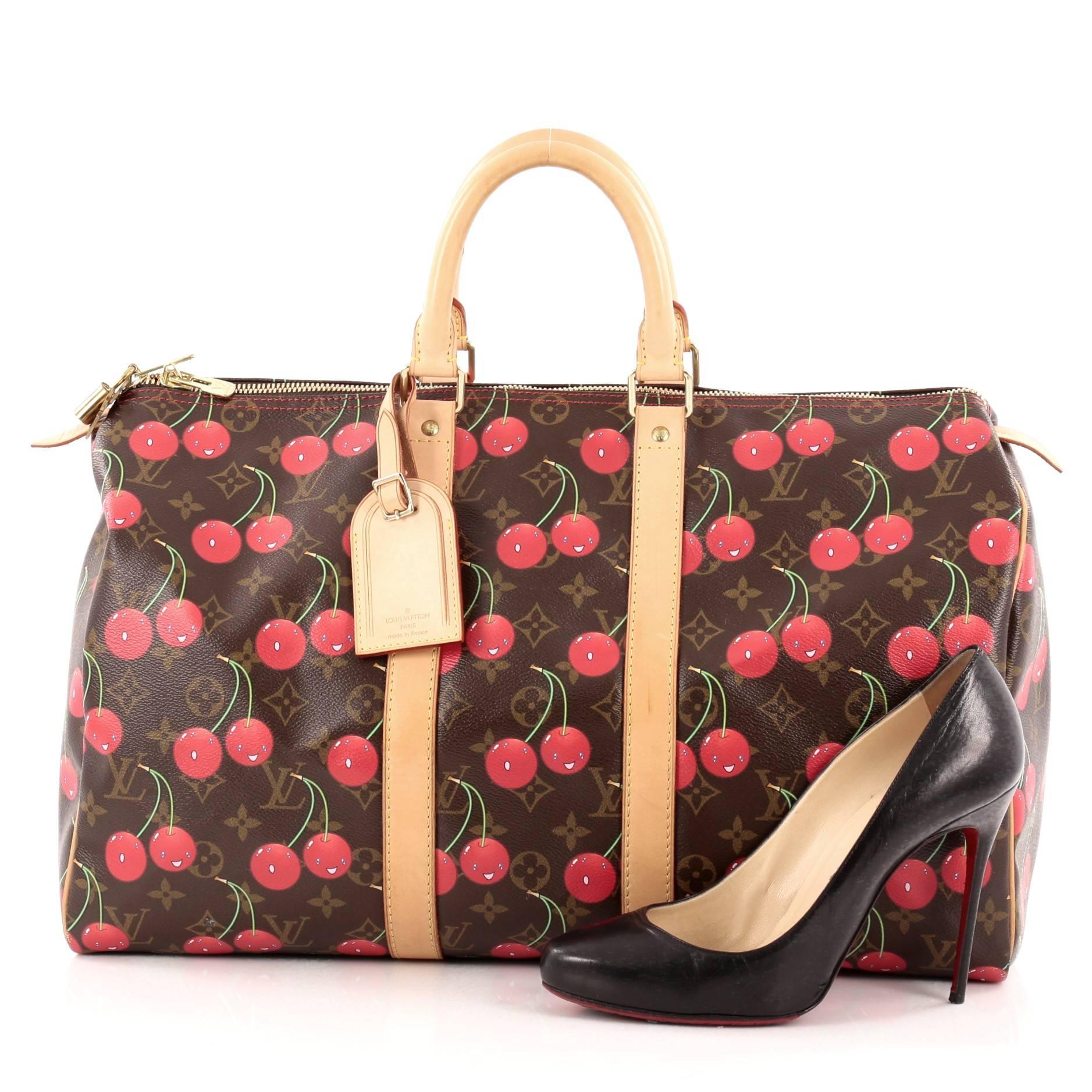 This authentic Louis Vuitton Keepall Bag Limited Edition Cerises 45 is a must-have travel bag for LV collectors everywhere. Crafted from brown monogram canvas adorned with bright cheerful cherries, this limited edition luggage features dual-rolled