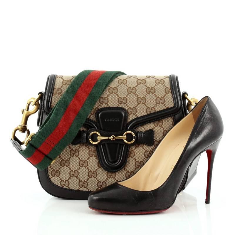 This authentic Gucci Lady Web Shoulder Bag GG Canvas Medium is a style that echoes seventies glamour that beautifully reinterprets quintessential Gucci style. Crafted from brown GG monogram canvas with black leather trims, this bag features