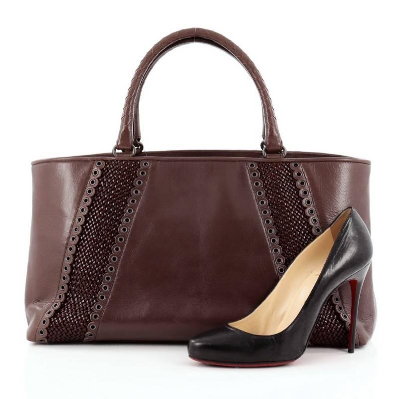 This authentic Bottega Veneta Rugiada Tote Intrecciato Leather with Grommet Detail Medium is a marvelous tote for everyday use. Crafted from brown leather, this sophisticated tote features dual-woven top handles, beautiful grommet and woven leather