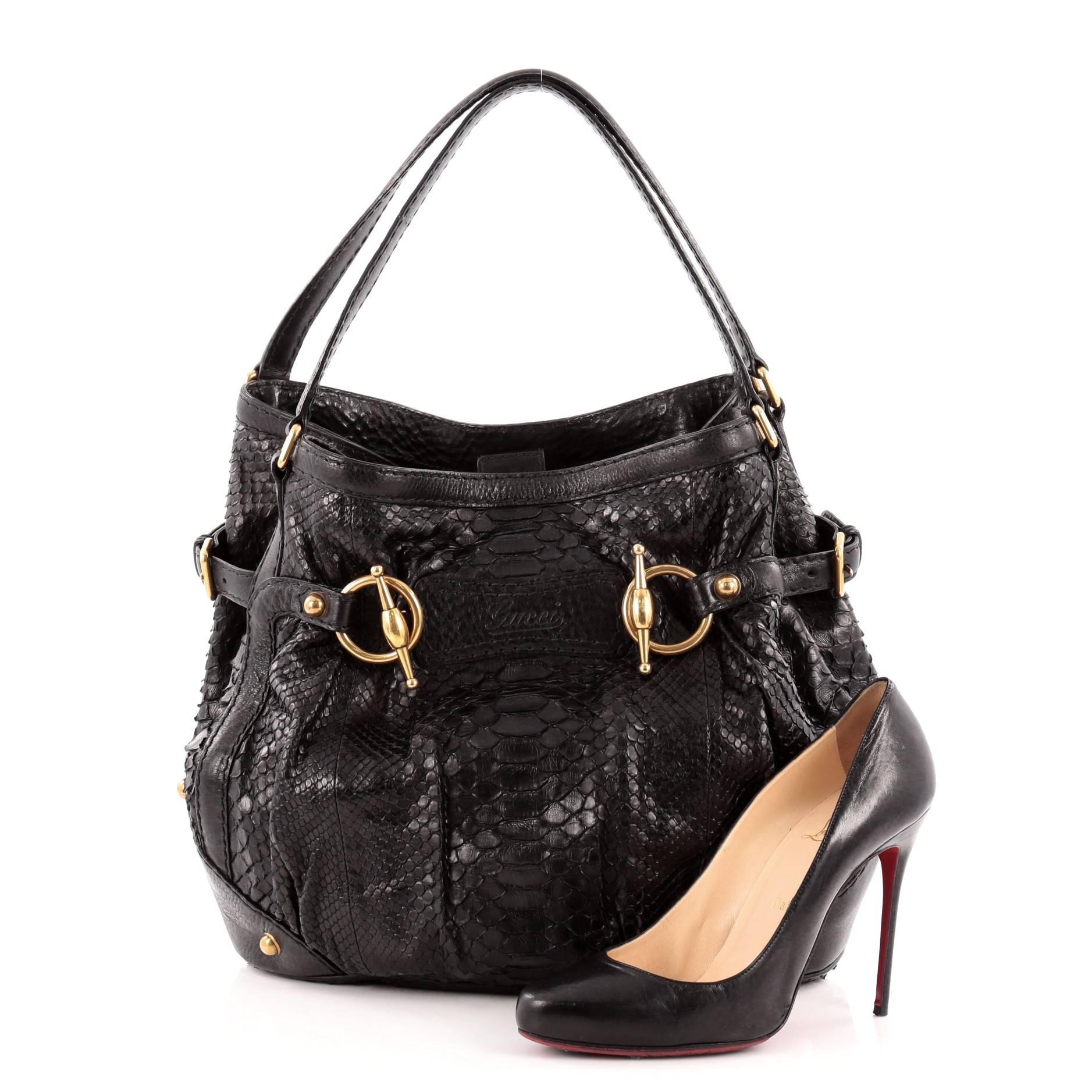 This authentic Gucci Jockey Tote Python Medium is perfect for all seasons. Crafted from black genuine python skin, this luxurious tote features dual-flat leather top handles, black leather trims, decorative horsebit detailing, handwritten logo, and