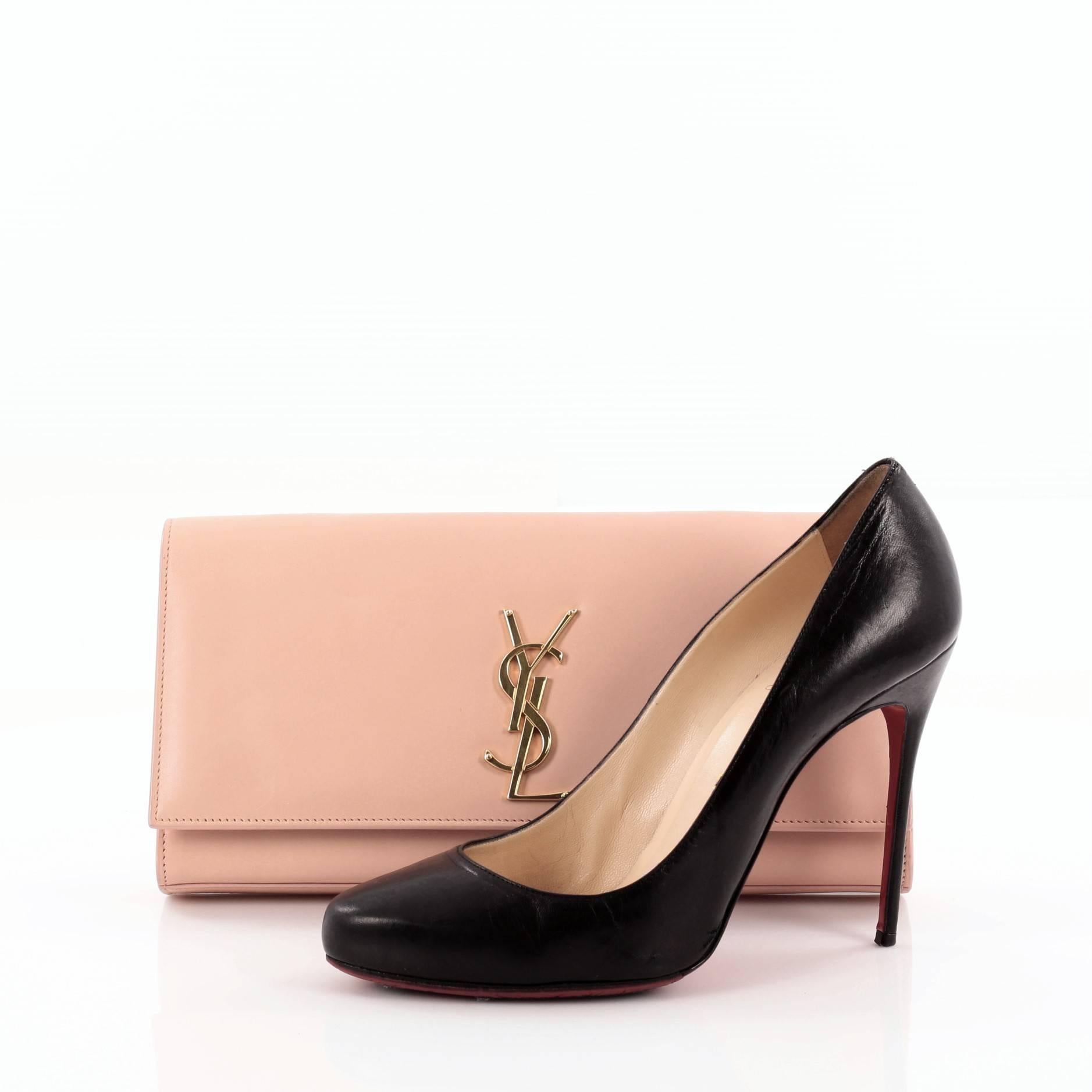 This authentic Saint Laurent Classic Monogram Clutch Leather Medium adds a touch of glamour to everyday looks. Crafted in pale pink leather, this elegant clutch features an iconic gold YSL monogram logo on its flap and gold-tone hardware accents.
