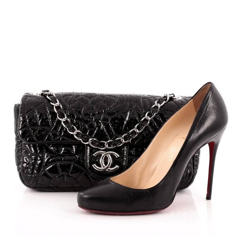 This authentic Chanel Graphic Edge Flap Bag Quilted Patent Vinyl Medium is chic and fabulous made for the modern woman. Crafted from black patent vinyl embroidered with an abstract camellia flower pattern, this stand-out flap features woven-in