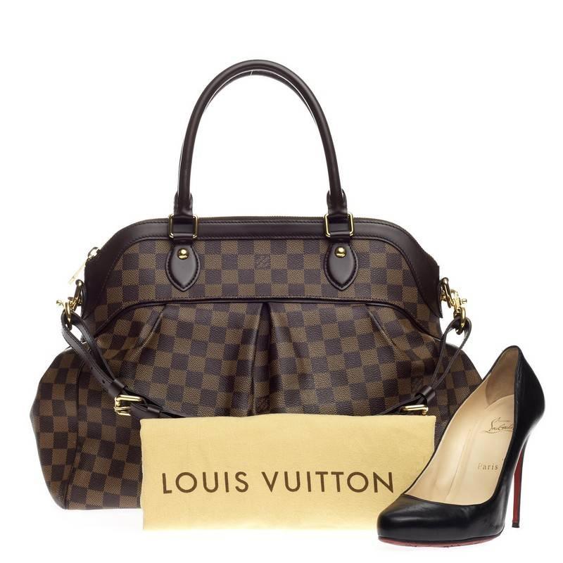 This authentic Louis Vuitton Trevi Damier GM inspired by the Trevi Fountain is a chic and versatile handle bag. Crafted from classic damier ebene coated canvas, this tote features dual-rolled handles, brown leather trims, subtle pleats in the middle