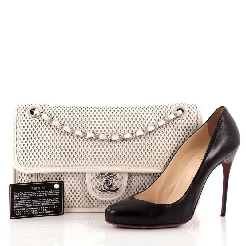 This authentic Chanel Up In The Air Flap Bag Perforated Leather Medium presented in the brand's Pre-Spring and Summer 2013 Collection showcases a sporty-chic update to Chanel's beloved classic flaps. Crafted in lightweight white perforated leather,