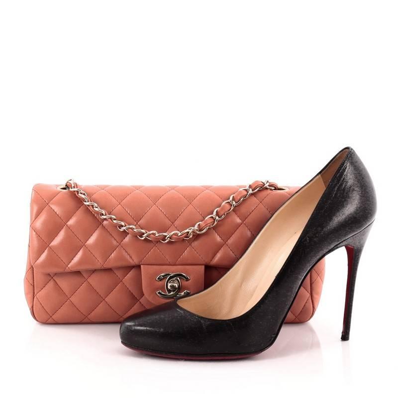 This authentic Chanel Classic Single Flap Bag Quilted Lambskin East West is a classic design perfect for transitioning from day-to-evening looks. Crafted from luxurious coral peach lambskin leather in signature diamond quilting, this elongated flap