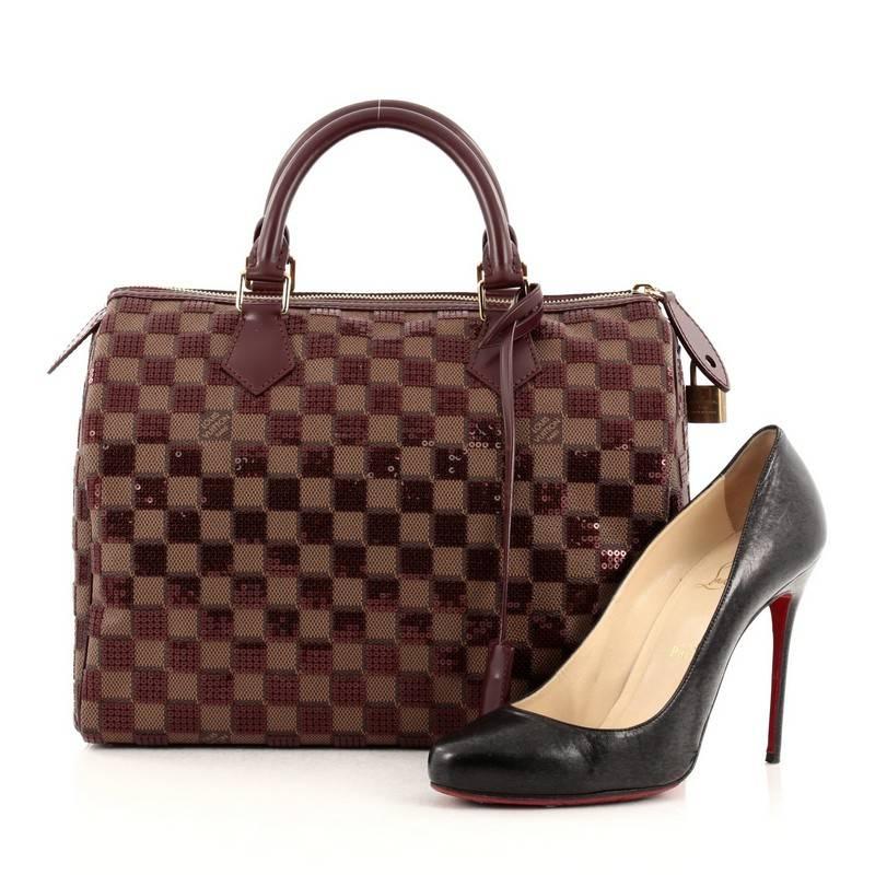 This authentic Louis Vuitton Speedy Handbag Damier Paillettes 30 inspired by the geometric spirit of the brand's Spring/Summer 2013 Collection is a sophisticated and glamorous must have made for any Louis Vuitton lover. Constructed in damier ebene