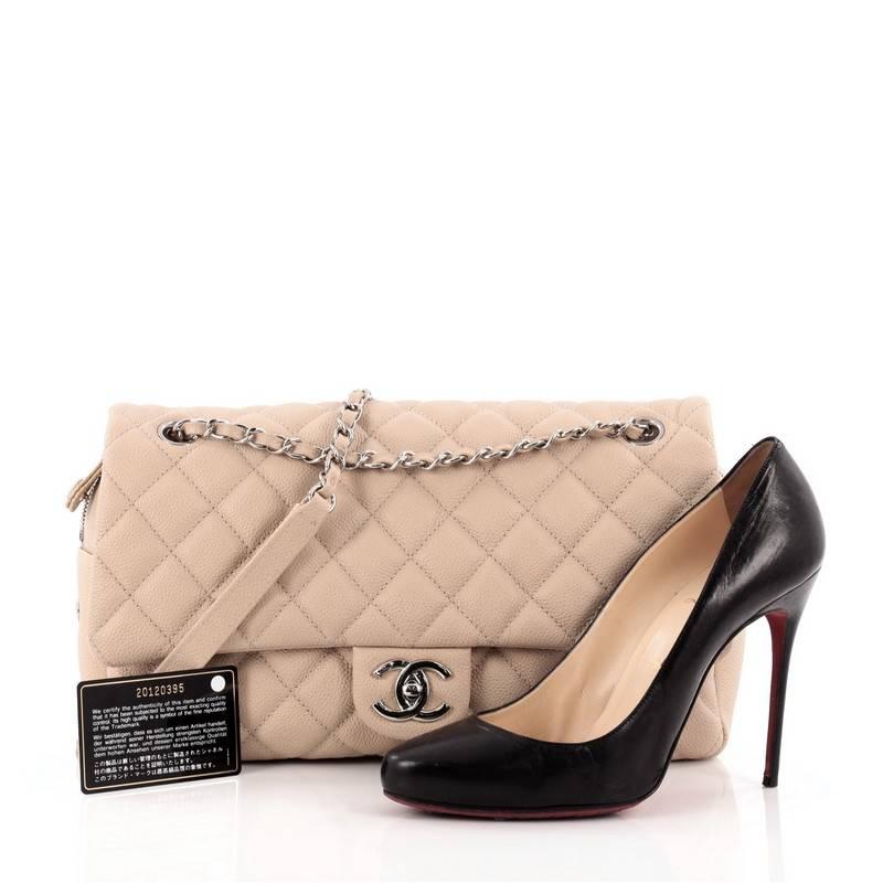 This authentic Chanel Easy Flap Bag Quilted Caviar Jumbo exudes a classic yet easy style made for the modern woman. Crafted from nude caviar leather with Chanel's signature diamond quilting design, this elegant flap features dual woven-in leather