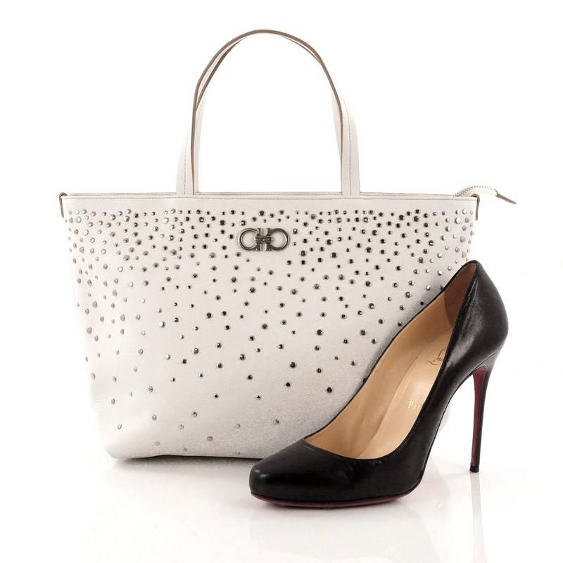 This authentic Salvatore Ferragamo Bice Tote Studded Leather is a sleek and stylish accessory made for every fashionista. Crafted from stunning white leather, this tote embellishes multiple mini studs, signature Gancini hardware at its center, dual