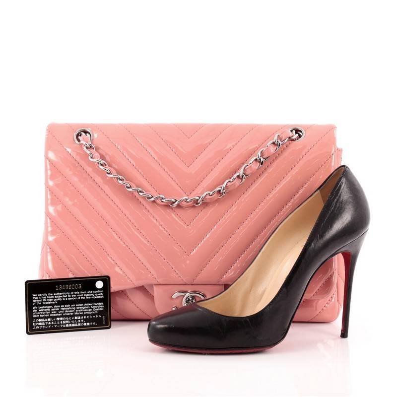 This authentic Chanel Classic Single Flap Bag Chevron Patent Jumbo is a timeless essential for any modern woman. Crafted in bubble gum pink patent leather, this large classic flap features woven-in leather silver chain strap, Chanel's chevron