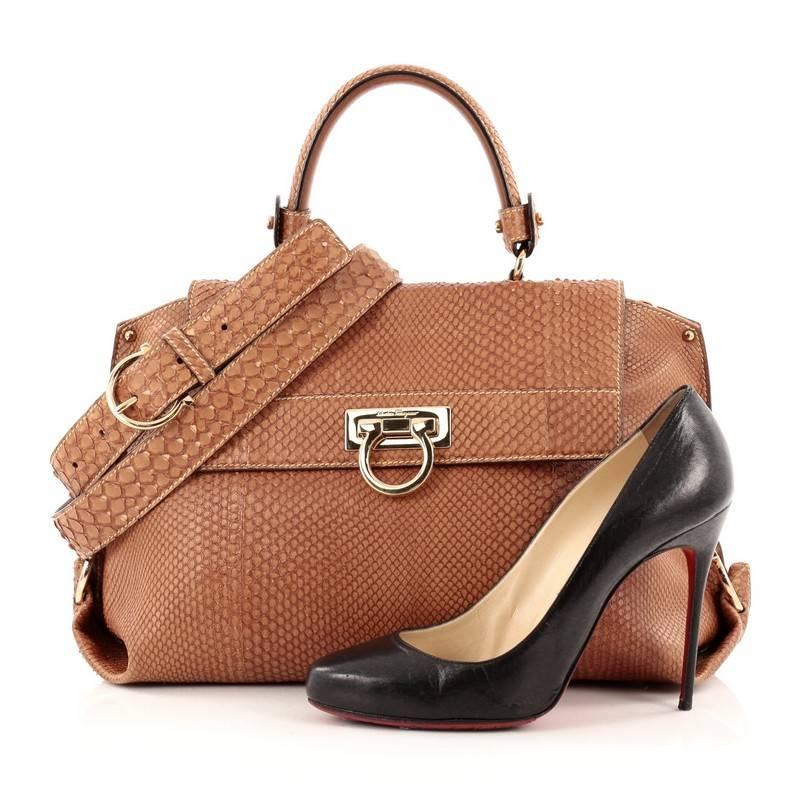 This authentic Salvatore Ferragamo Sofia Satchel Python Medium is a stylish and functional, chic bag perfect for the modern woman. Crafted in brown genuine python skin, this luxurious bag features a single rolled python handle, exterior back zip