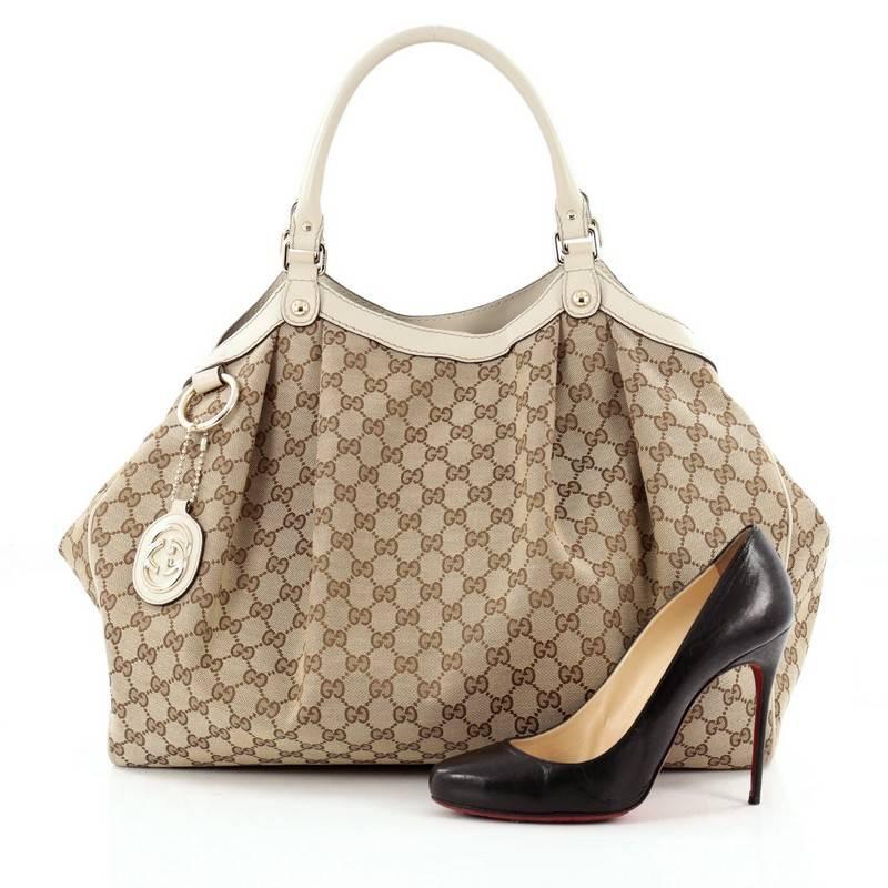 This authentic Gucci Sukey Tote GG Canvas Large is perfect for any casual or sophisticated outfit. Constructed from Gucci's beige GG canvas with off-white leather trims, this roomy tote features dual-rolled leather handles that sit comfortably on