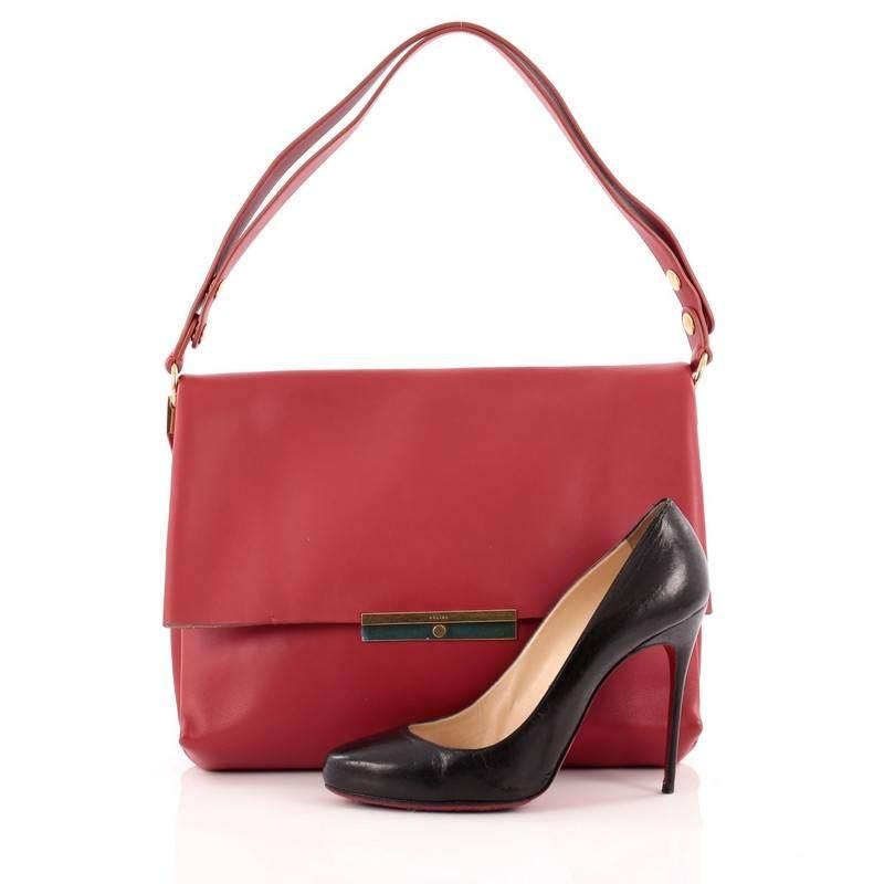 This authentic Celine Blade Shoulder Bag Leather is an elegant, minimalistic bag for any casual or sophisticated outfit. Crafted in red leather, this versatile bag features a flat leather shoulder with thebutton snaps that lengthen the strap and