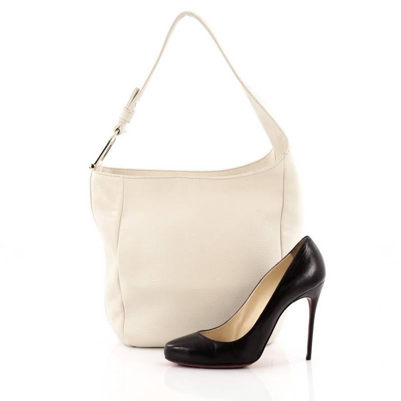 This authentic Gucci Greenwich Hobo Leather Small is simple and minimalist in design perfect for everyday use. Crafted in off-white grainy leather, this beautiful hobo features a single, asymmetrical looped leather handle with silver-tone spur