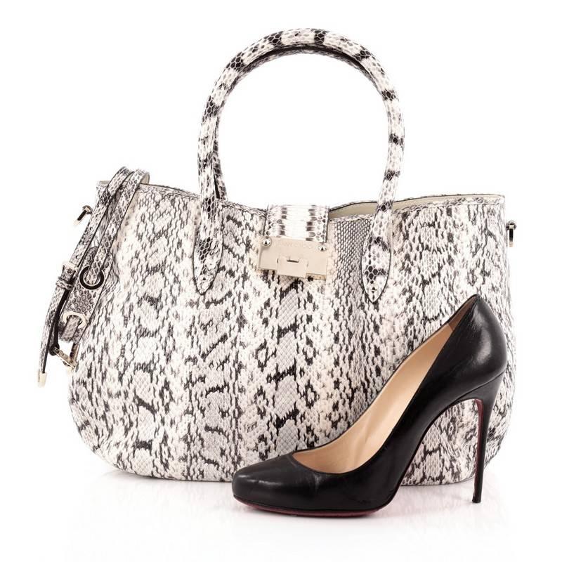 This authentic Jimmy Choo Rania Convertible Satchel Elaphe Large is an easy, spacious, hand-held tote bag that's perfect for your everyday looks. Crafted from black and white genuine elaphe snakeskin, this exotic chic bag features dual rolled