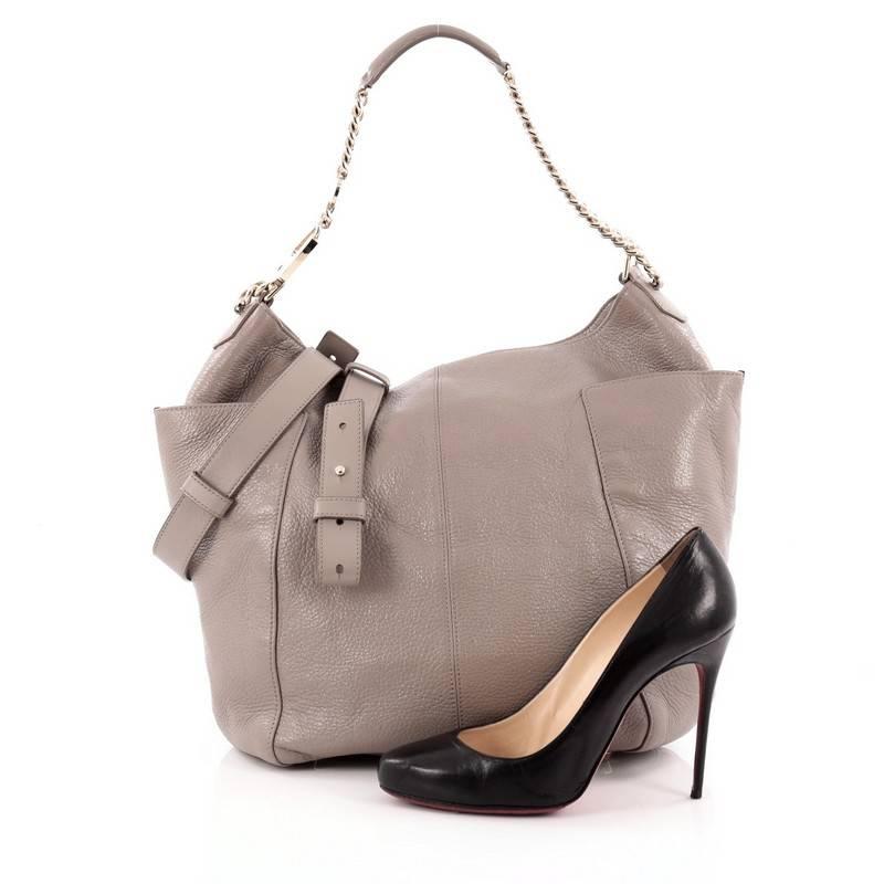 This authentic Jimmy Choo Anna Tote Leather in a sophisticated and simple design is perfect for modern woman. Crafted in grey leather, this eye-catching feminine bag features a gold chain strap with leather pad, exterior side pockets, protective