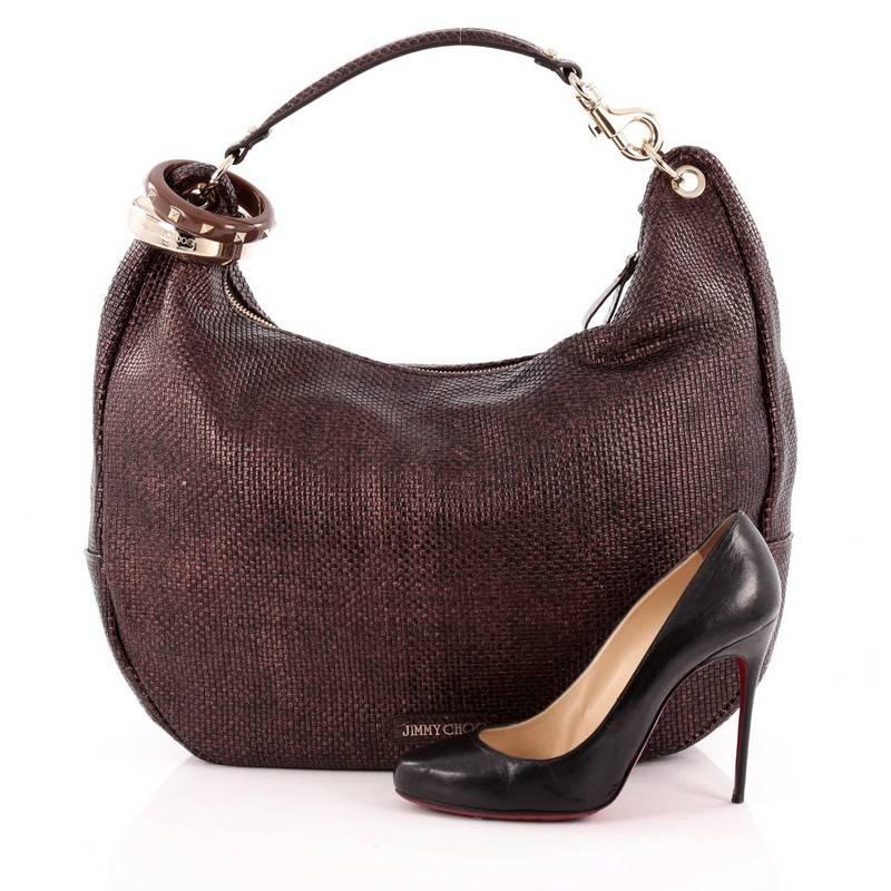 This authentic Jimmy Choo Solar Hobo Woven Leather Large is an eye-catching daily bag for the on-the-go woman. Constructed in dark brown woven leather, this hobo features snakeskin top handle, oversized studded and metal bangles and gold-tone