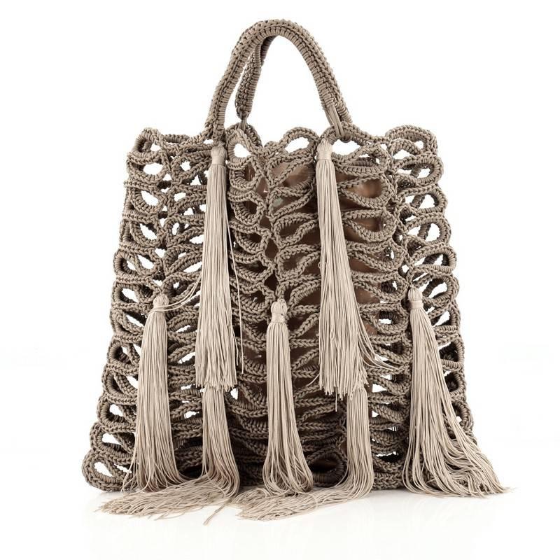 This authentic Jimmy Choo Delilah Tote Crochet Rope with Tassels Large is spacious and strikingly fun, fashion piece. Crafted from grey crochet rope with playful tassels, this bag features dual woven handles, detachable internal zip pouch with