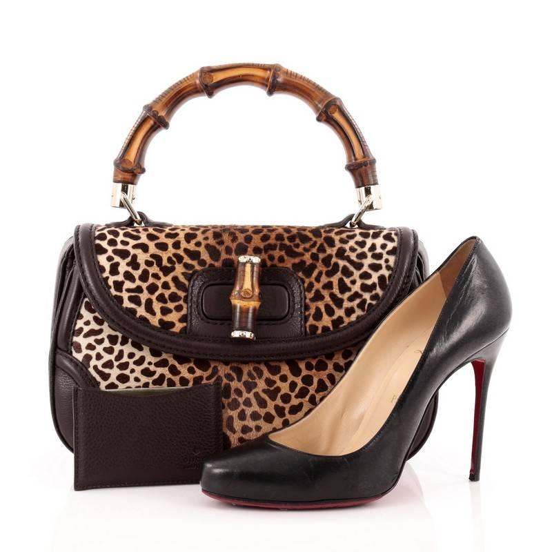 This authentic Gucci New Bamboo Convertible Top Handle Bag Printed Pony Hair Medium is unmistakably a classic Gucci design created in 2011 for Gucci's 90th Anniversary. Crafted in brown and black cheetah print pony hair with dark brown leather