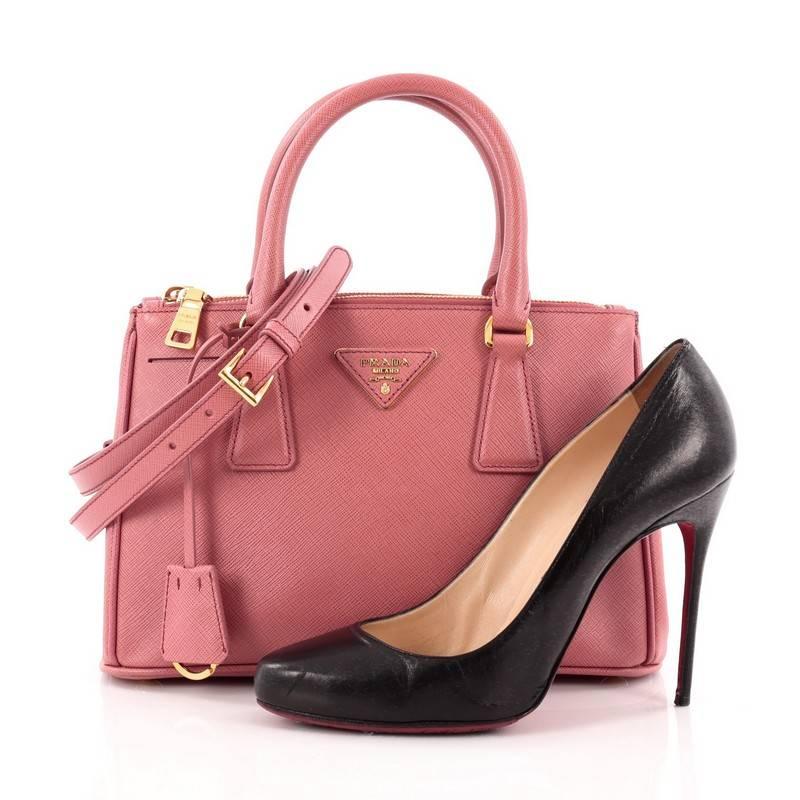 This authentic Prada Double Zip Lux Tote Saffiano Leather Mini is the perfect bag to complete any outfit. Crafted from tamaris pink saffiano leather, this boxy, petite tote features side snap buttons, raised Prada logo, dual-rolled leather handles,