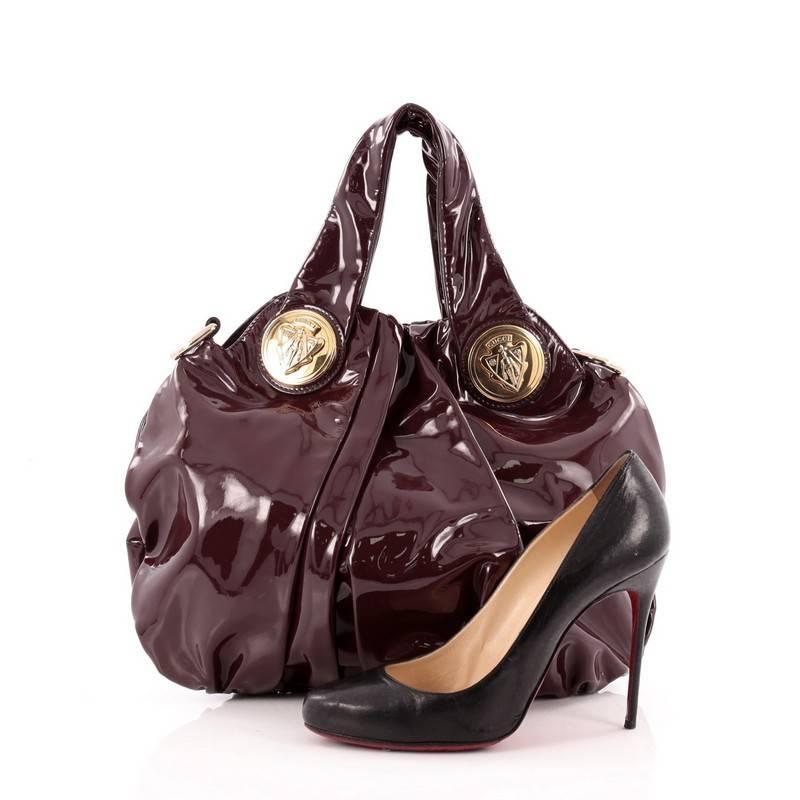 This authentic Gucci Hysteria Convertible Top Handle Bag Patent Small is a lovely accessory for any Gucci lover showcasing an easy-casual yet elegant design. Crafted from burgundy patent leather, this luxurious hobo showcases dual shoulder straps