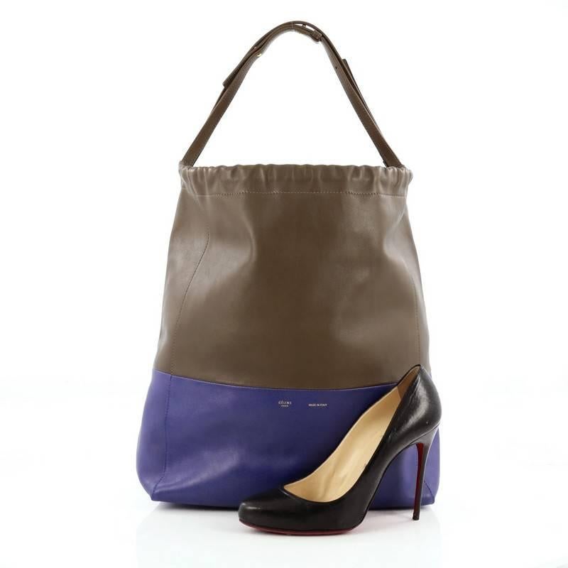 This authentic Celine Bicolor Drawstring Cabas Tote Leather is from the brand's Spring 2012 Cabas Bag Collection that's perfect everyday accessory for the woman on-the-go. Crafted from two-toned blue and taupe leather, this minimalist bag features