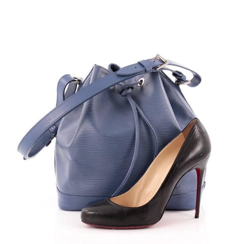 This authentic Louis Vuitton Noe NM Handbag Epi Leather BB is a chic and iconic bag that is a highly sought-after bucket style for the modern fashionista. Crafted from blue epi leather, this modern bucket bag features adjustable shoulder straps that