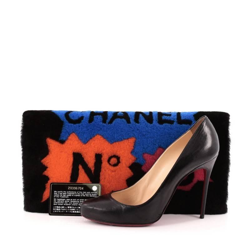 This authentic Chanel No.5 Comic Clutch Shearling presented in the brand's Fall/Winter 2014 Collection boasts an avant-garde, runway-ready style made for daring fashionistas. Crafted from plush black and multicolor shearling with black lambskin