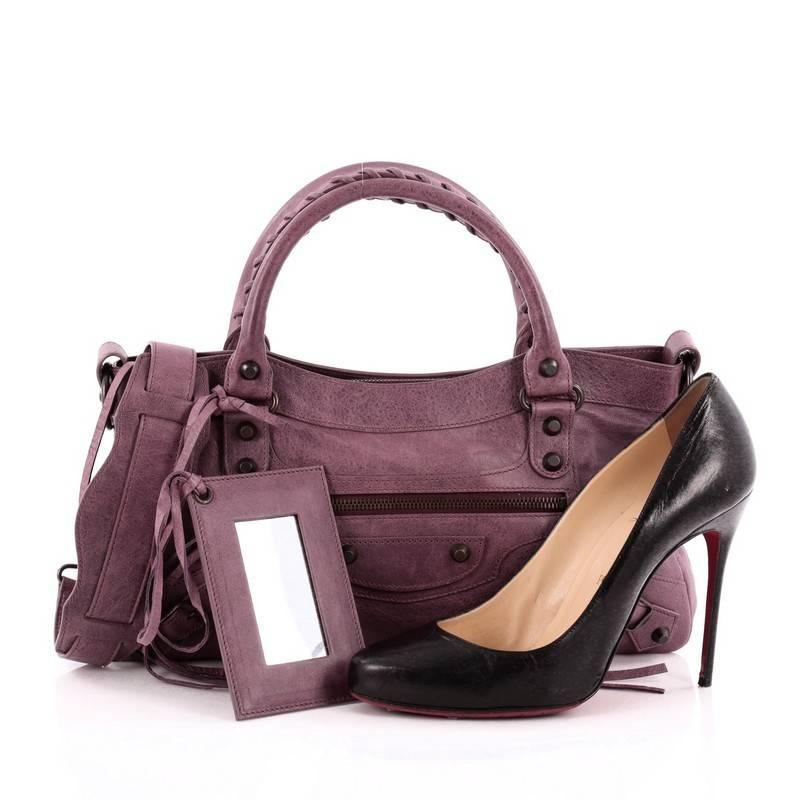 This authentic Balenciaga First Classic Studs Handbag Leather is an easy-to-carry accessory that can be paired with any outfit. Constructed from purple leather, this everyday bag features braided woven handles, long fringe detailing, exterior front