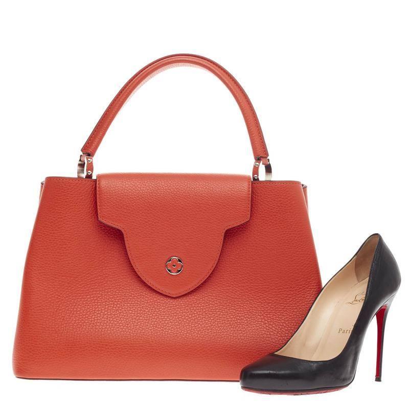 This authentic Louis Vuitton Capucines Leather MM is sophisticated and ladylike luxurious bag from the brand's Fall 2013 Collection inspired by its Parisian heritage. Crafted in orange taurillon leather, this chic, stand-out bag features a single