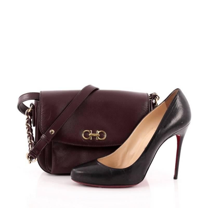 This authentic Salvatore Ferragamo Sandrine Shoulder Bag Leather is perfect for on-the-go fashionistas. Crafted in burgundy textured leather, this shoulder bag features a long leather strap with chains, Gancini gold logo at its flap and gold-tone