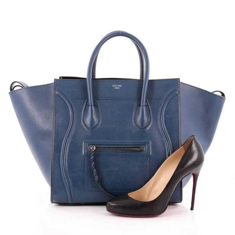 This authentic Celine Phantom Handbag Textured Leather Medium is one of the most sought-after bags beloved by fashionistas. Crafted from blue textured leather, this minimalist tote features dual-rolled handles, an exterior front pocket, protective