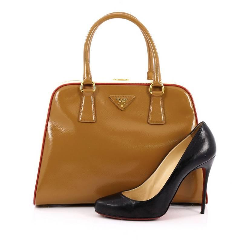 This authentic Prada Pyramid Top Handle Bag Vernice Saffiano Leather Medium mixes a classic and edgy design made for the modern woman. Constructed in brown and white glossy vernice saffiano leather, this stylish bag features dual-rolled leather